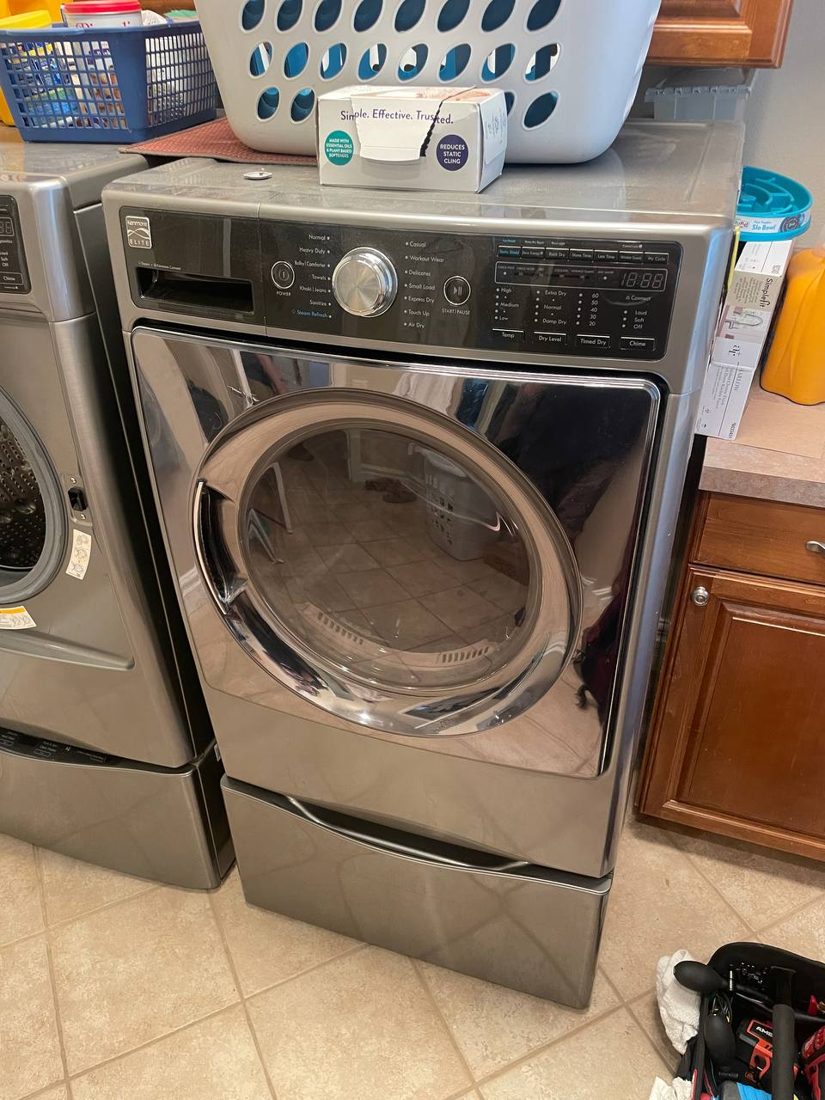 Pedestal-mounted dryer in a Poulsbo laundry room ahead of service